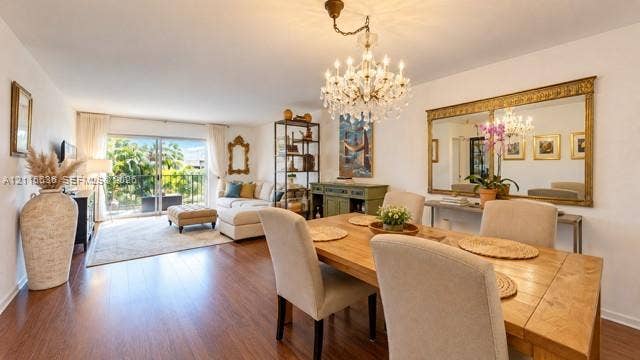 3860 NE 170th Street, #310, North Miami Beach, FL 33160 Wood-finish flooring, crystal-style chandelier, large decorative wall mirror with gold-tone frame, and sliding glass doors