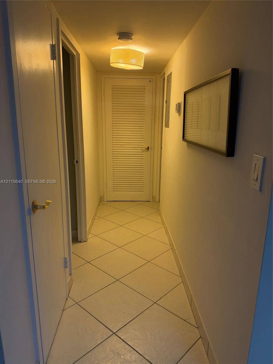 1913 S Ocean Drive, #426, Hallandale Beach, Hallandale Beach, FL 33009 Hallway featuring diagonal-set tile flooring, a louvered door, and a drum-style ceiling light fixture