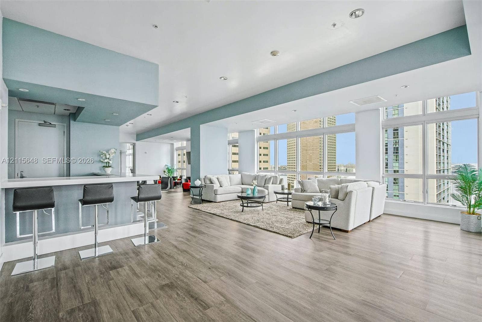 300 S Biscayne Boulevard, #T-3604, Miami, FL 33131 Open-concept floor plan featuring expansive floor-to-ceiling windows, wood-finish flooring, recessed lighting, and a built-in wet bar with a stone-top counter