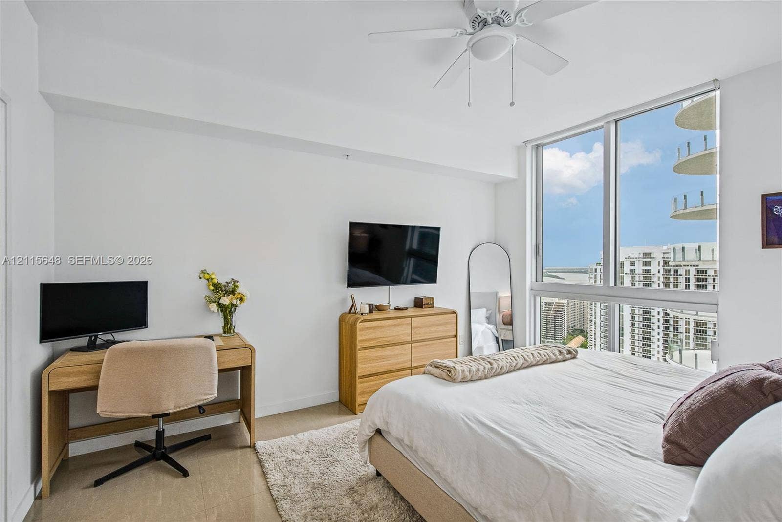300 S Biscayne Boulevard, #T-3604, Miami, FL 33131 Floor-to-ceiling windows, neutral hard-surface flooring, and a ceiling-mounted fan