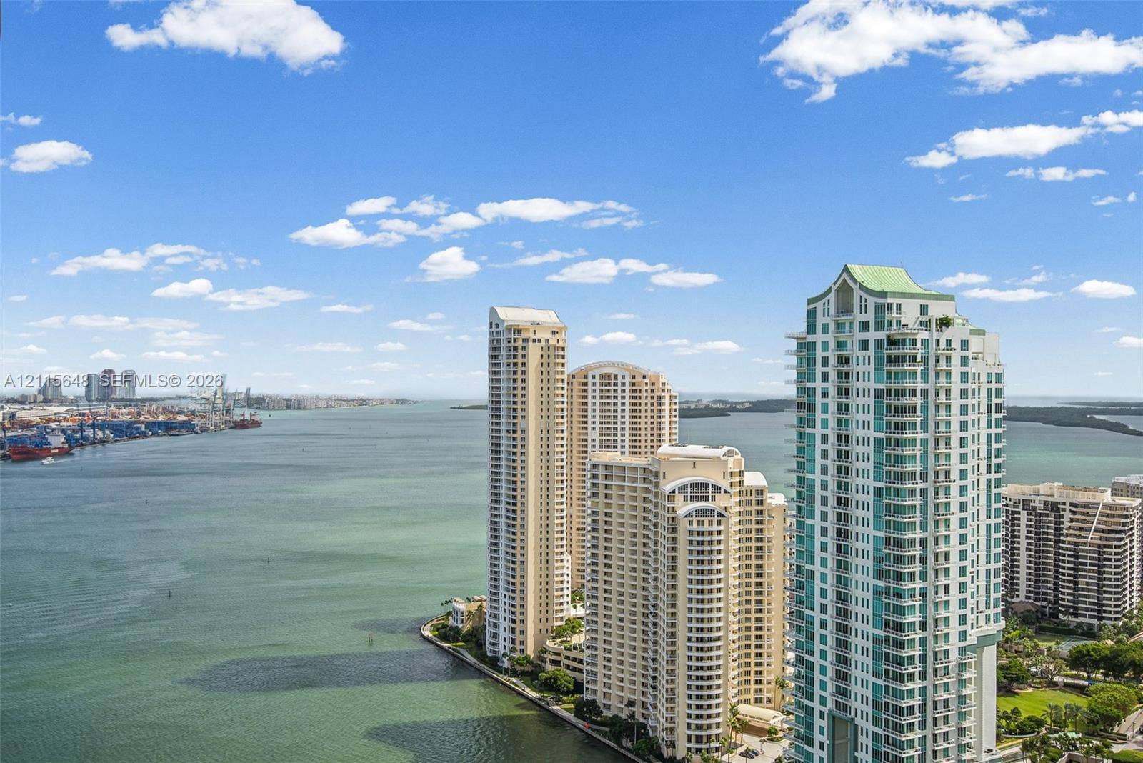 300 S Biscayne Boulevard, #T-3604, Miami, FL 33131 High-rise residential tower featuring balconies, floor-to-ceiling glass windows, a distinctive peaked roofline, and waterfront positioning
