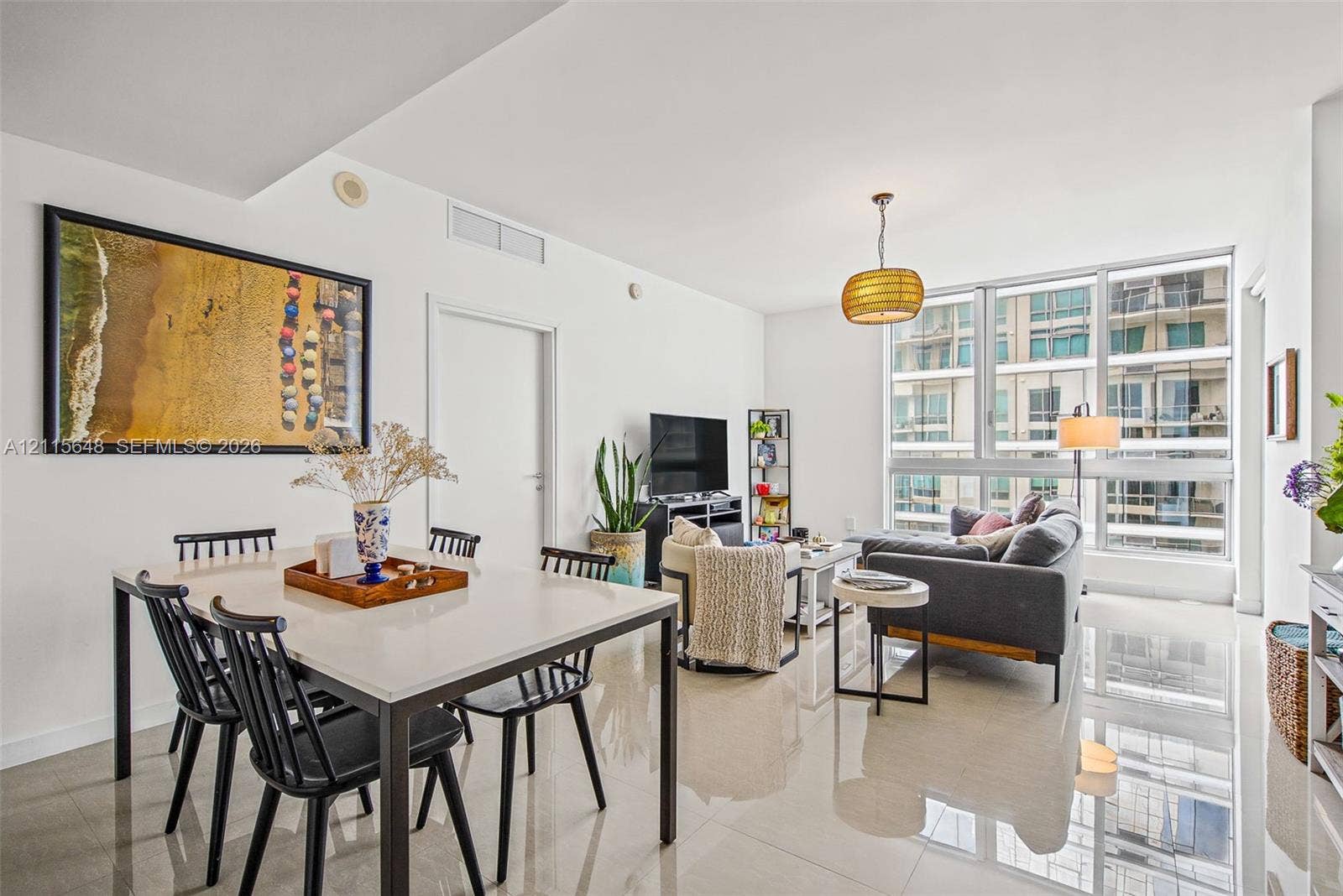 300 S Biscayne Boulevard, #T-3604, Miami, FL 33131 Open-concept interior featuring large-format polished tile flooring, floor-to-ceiling windows with expansive glass panels, and a statement pendant light fixture