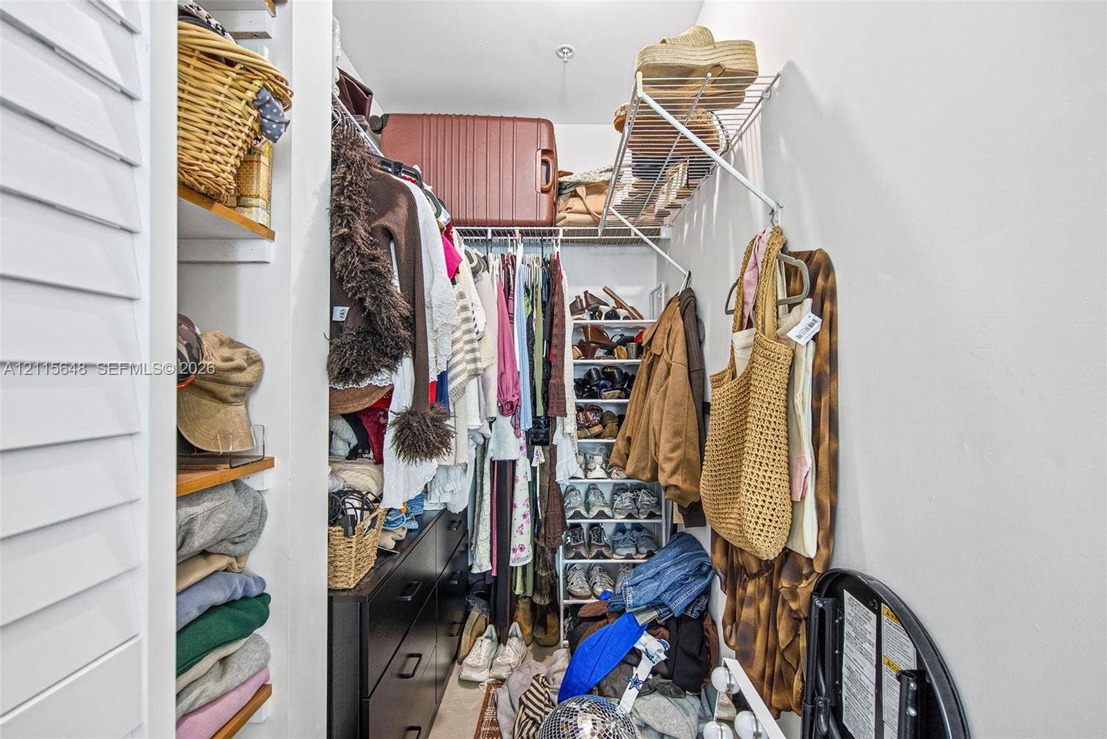 300 S Biscayne Boulevard, #T-3604, Miami, FL 33131 Walk-in closet featuring multi-tiered wire shelving, integrated wood-finish shelving units, and a shutter-style door