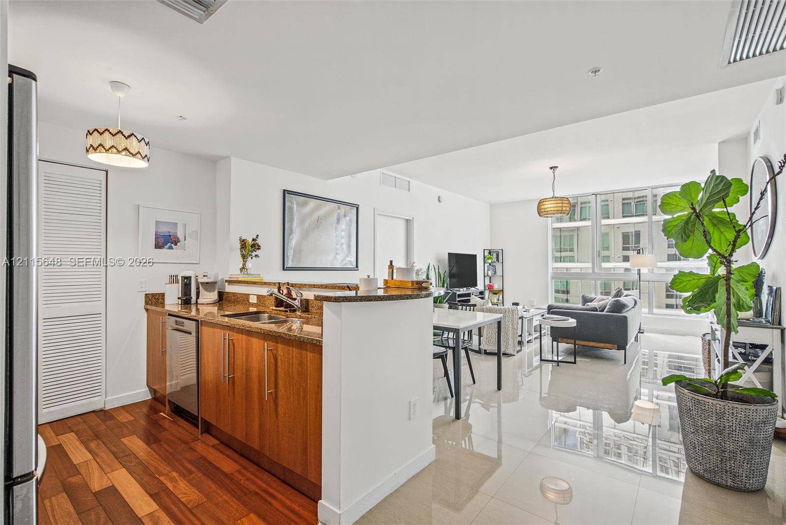 300 S Biscayne Boulevard, #T-3604, Miami, FL 33131 Kitchen featuring wood cabinetry, stone countertops, stainless steel dishwasher, and wood-finish flooring, complemented by floor-to-ceiling windows