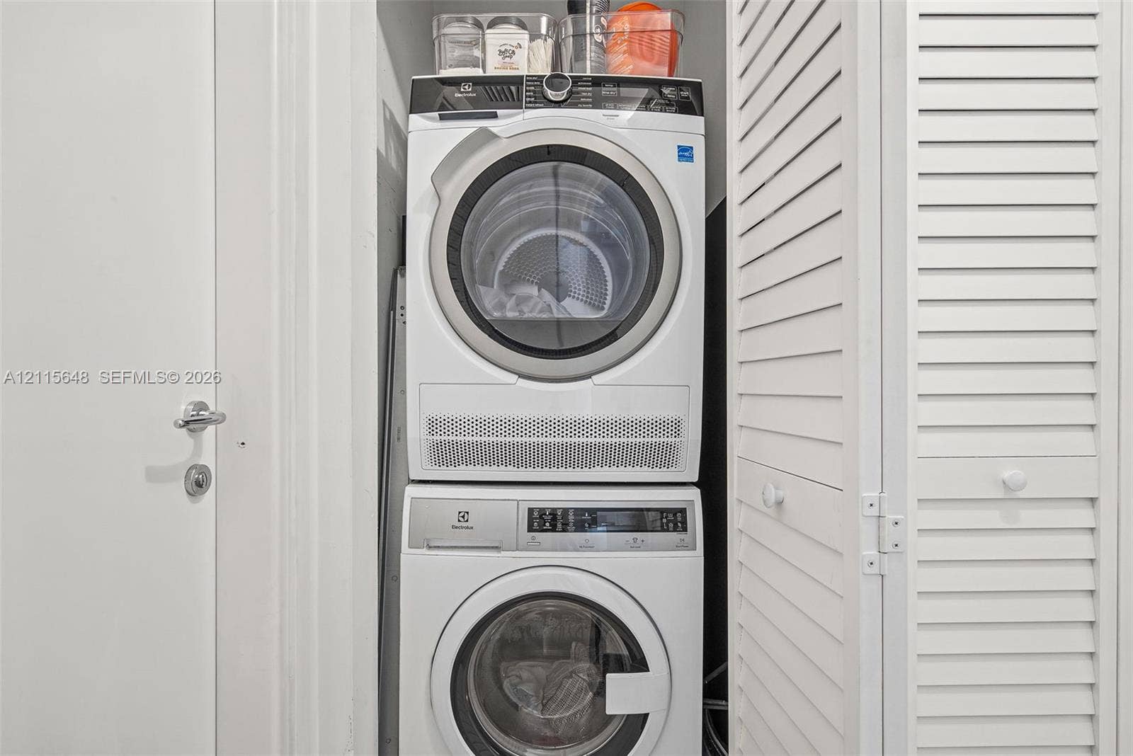300 S Biscayne Boulevard, #T-3604, Miami, FL 33131 Stacked Electrolux front-load washer and dryer unit enclosed by white louvered doors