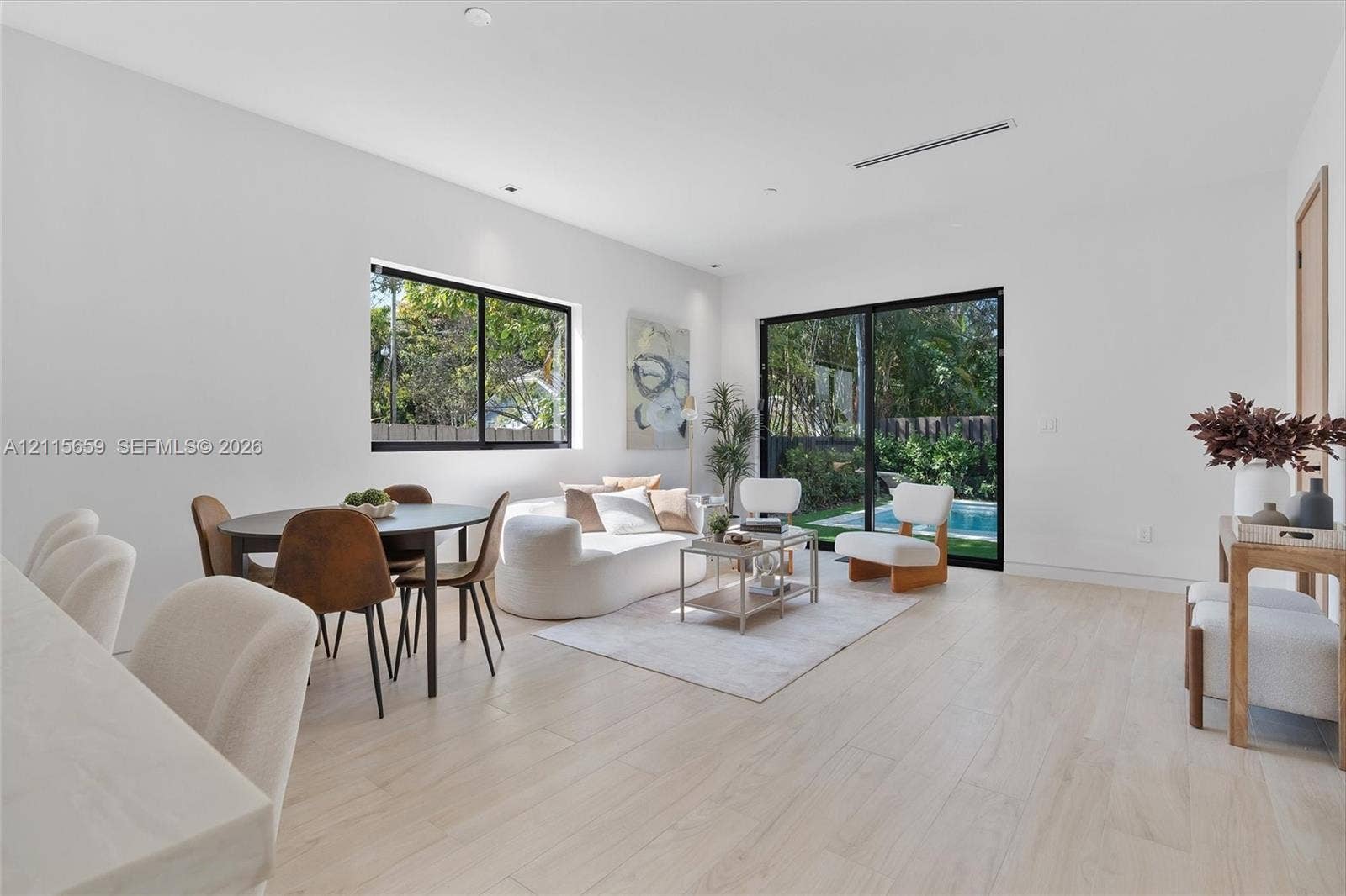 4719 N Miami Avenue, Miami, FL 33127 Living area featuring light-toned wood-finish flooring, sliding glass doors, recessed lighting, and a square window