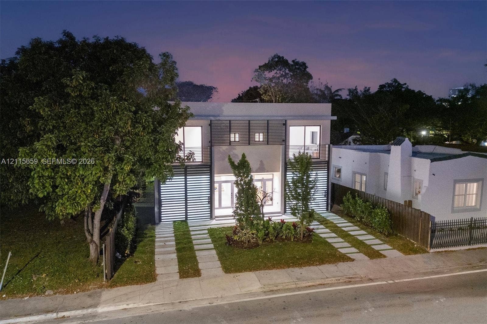 4719 N Miami Avenue, Miami, FL 33127 Modern two-story architectural exterior featuring smooth stucco finish, horizontal slat screening, and expansive glass entry doors