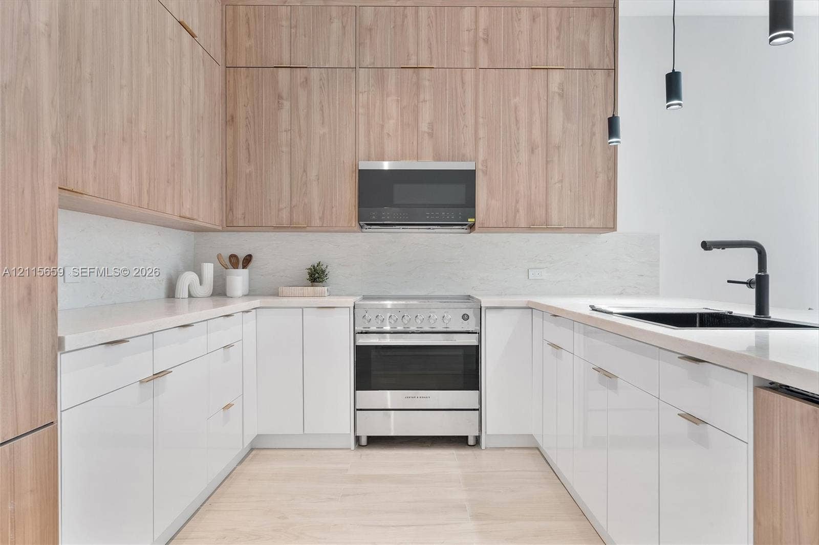 4719 N Miami Avenue, Miami, FL 33127 Kitchen featuring floor-to-ceiling wood-finish cabinetry, gloss white lower cabinetry, light-toned stone-finish countertops, stainless steel gas range with overhead microwave, and matte black plumbing fixtures