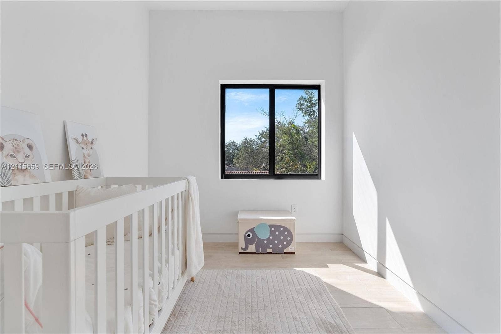 4719 N Miami Avenue, Miami, FL 33127 High-ceilinged room featuring wood-finish flooring and a black-framed window
