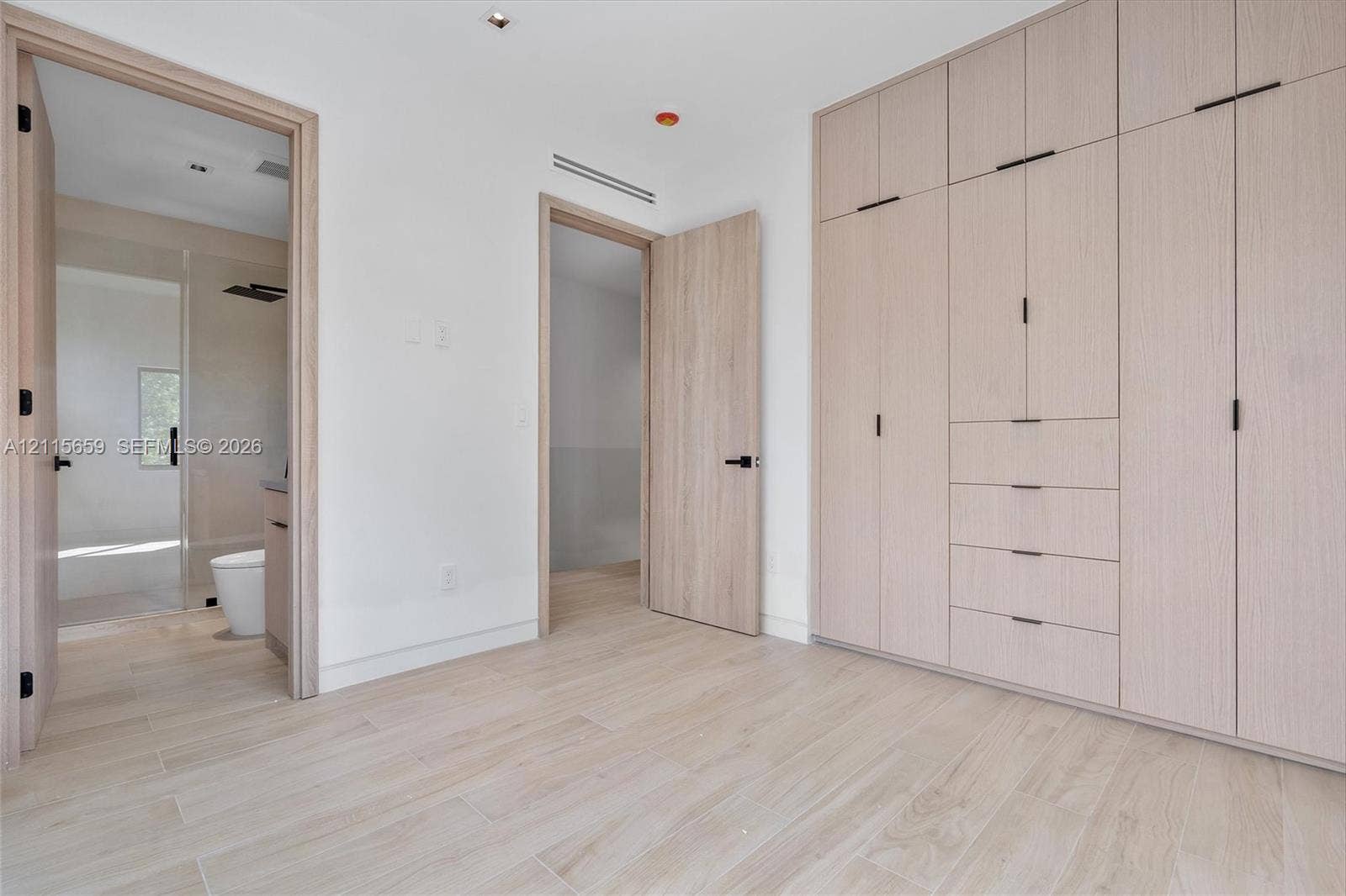 4719 N Miami Avenue, Miami, FL 33127 Floor-to-ceiling built-in cabinetry featuring integrated drawers and matte black hardware, wood-finish flooring, and recessed ceiling lighting