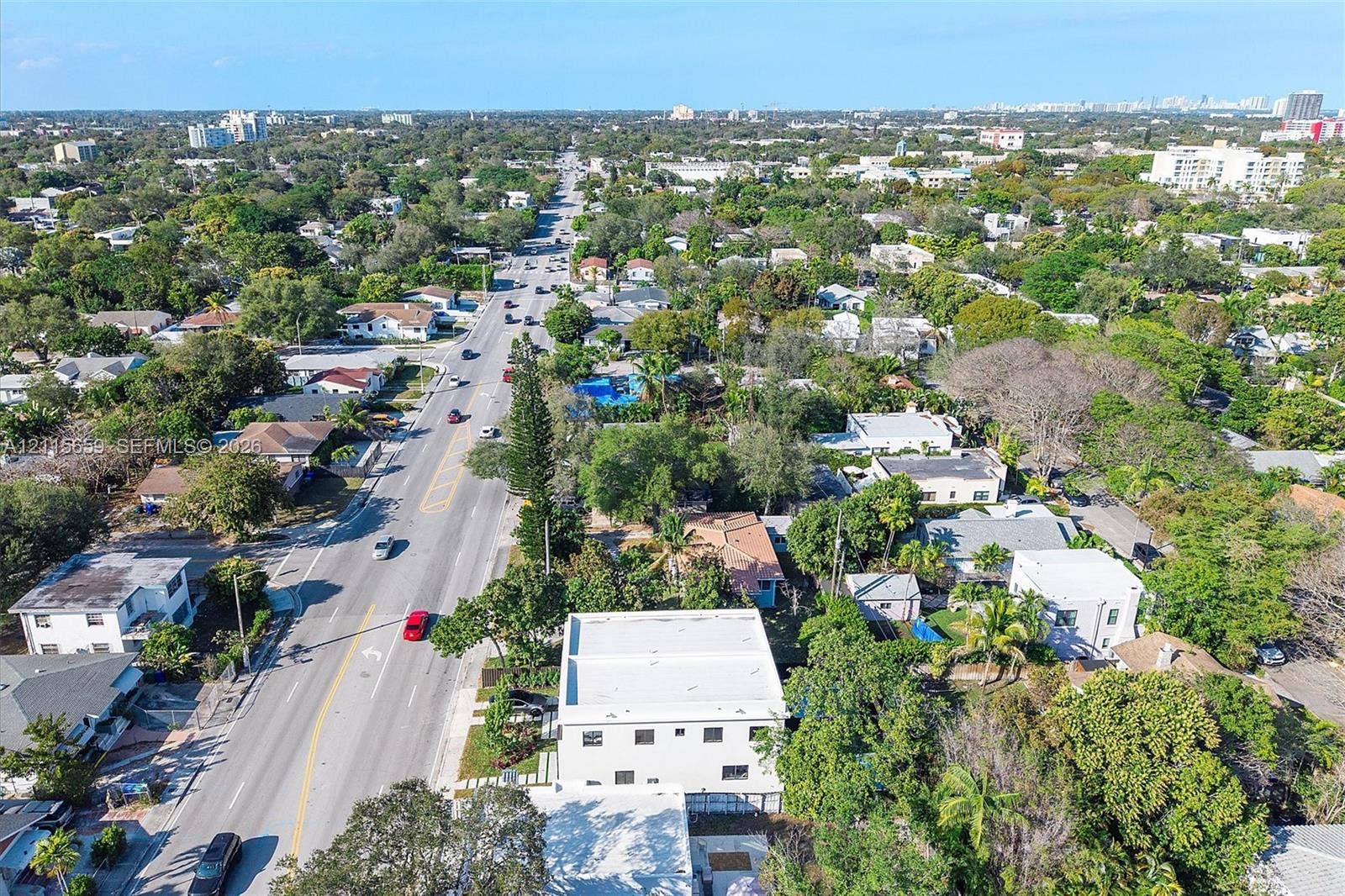 4719 N Miami Avenue, Miami, FL 33127 Aerial perspective of a multi-story structure featuring a flat roof and concrete-finish exterior, situated on a lot with established canopy trees and paved access