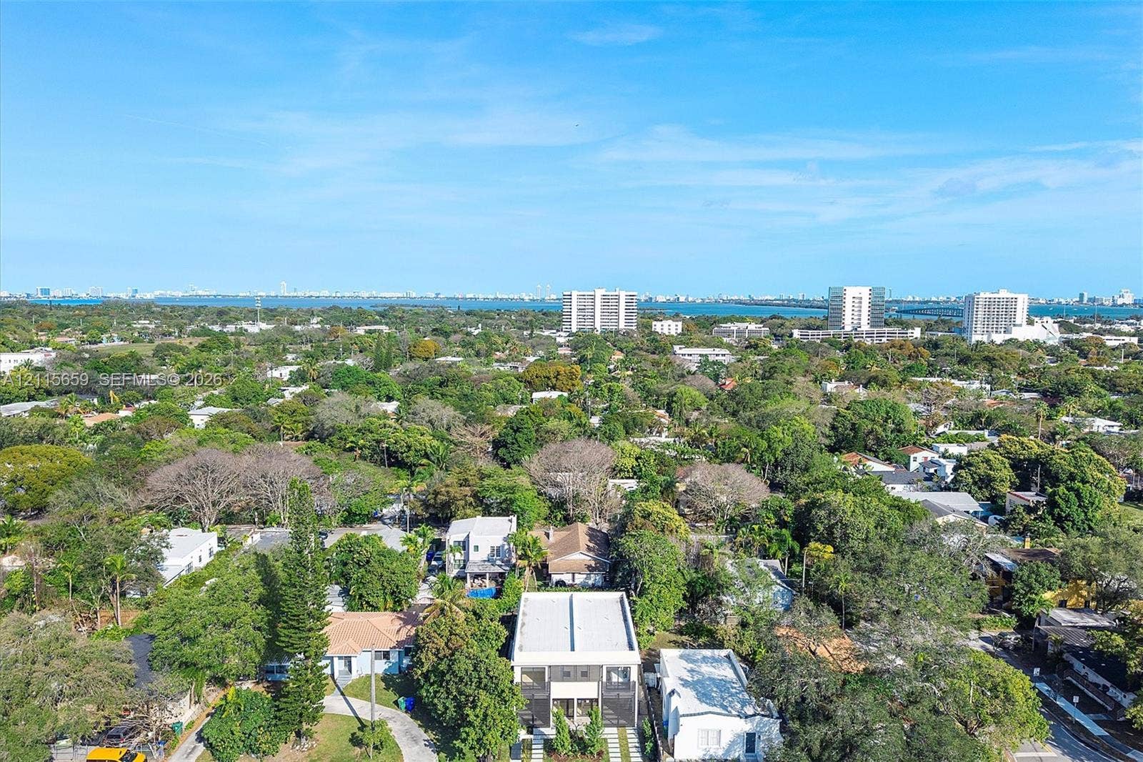 4719 N Miami Avenue, Miami, FL 33127 Aerial perspective of a multi-level residence featuring a flat roofline, paved driveway, and mature landscaping within a tree-lined residential area