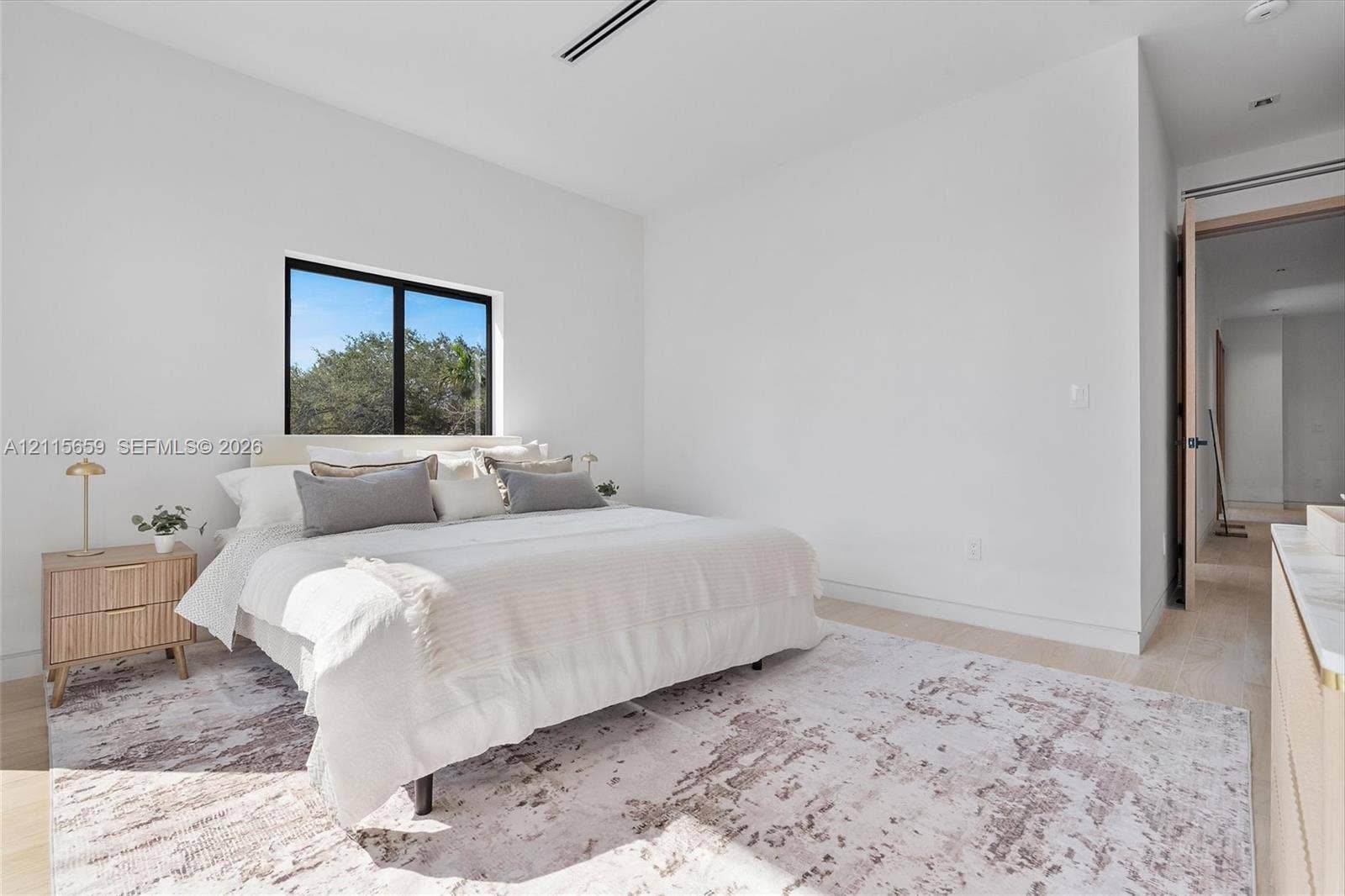 4719 N Miami Avenue, Miami, FL 33127 Neutral-toned room featuring wood-finish flooring, recessed ceiling lighting, and a window with a black frame