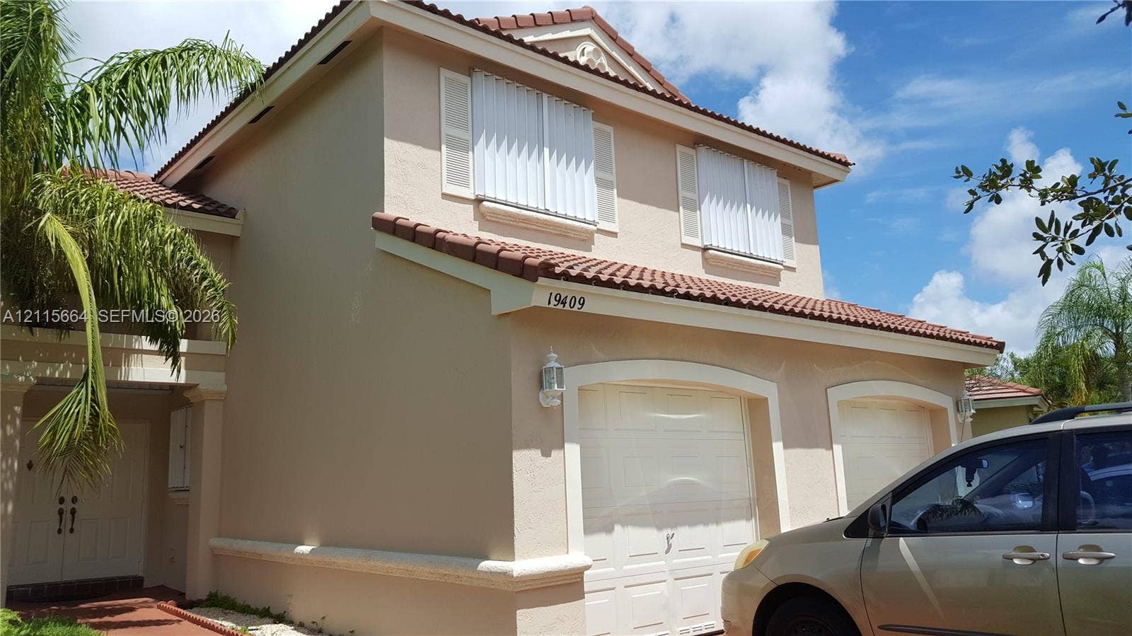 19409 NW 24th Place, Pembroke Pines, FL 33029 Two-story stucco exterior featuring a terra-cotta tile roof, a double-bay garage, and exterior shutters