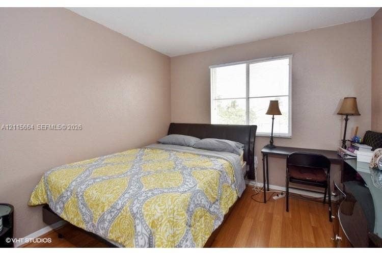 19409 NW 24th Place, Pembroke Pines, FL 33029 Neutral wall tones, wood-finish flooring, and a large window featuring horizontal blinds