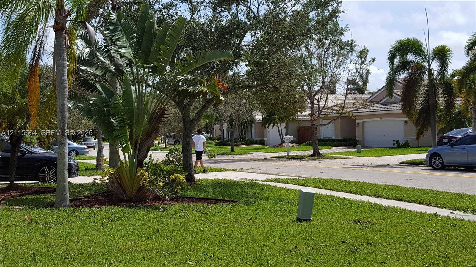 19409 NW 24th Place, Pembroke Pines, FL 33029 Single-story exterior featuring a hip roof, stucco siding, and an attached two-car garage, surrounded by landscaped grounds with mature palm trees