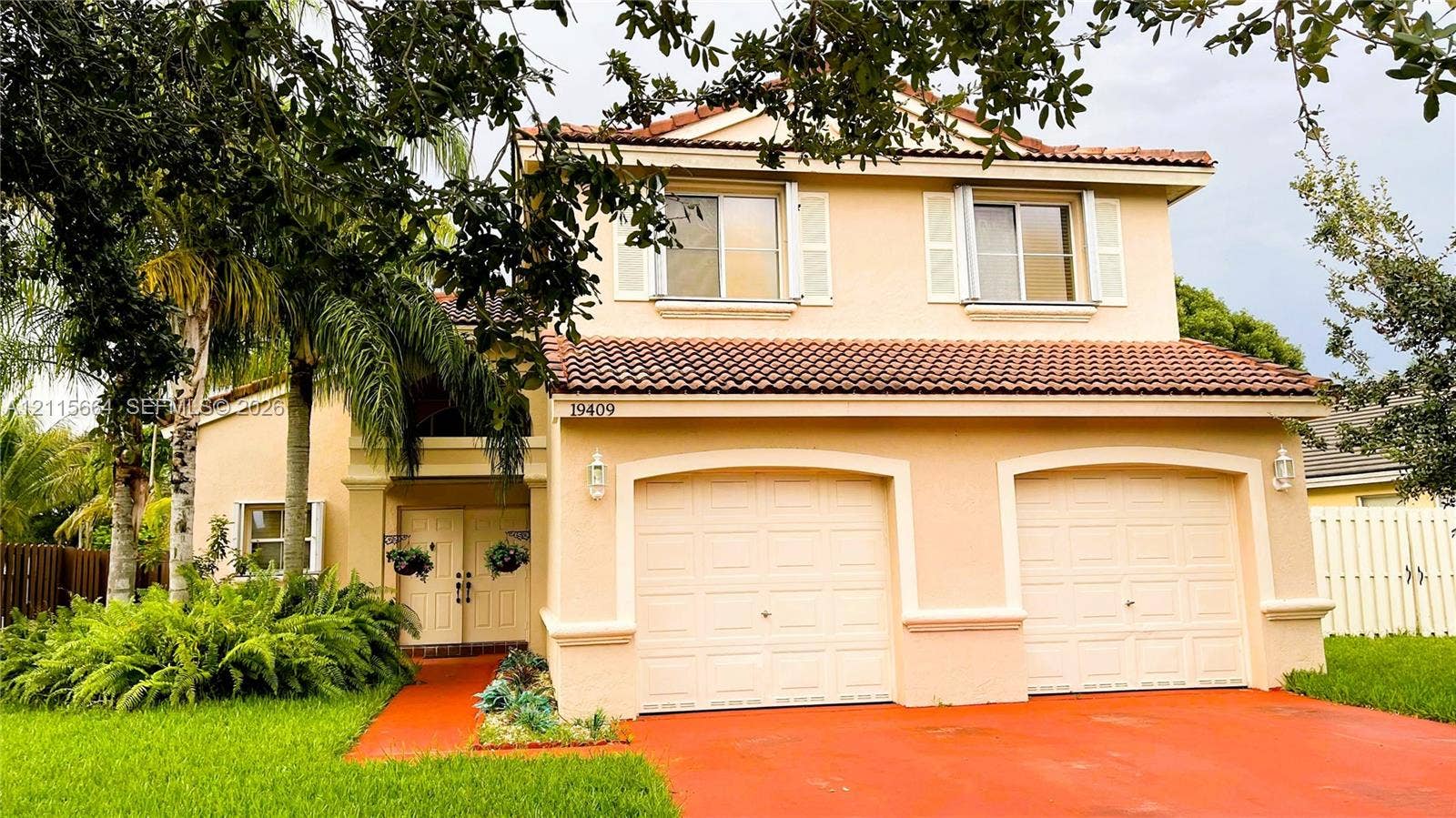 19409 NW 24th Place, Pembroke Pines, FL 33029 Two-story exterior featuring a stucco facade, dual-bay garage, tiled roof, and double-door entryway