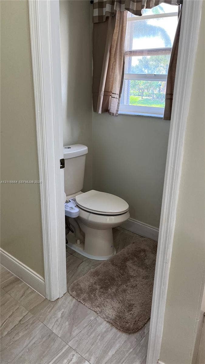 19409 NW 24th Place, Pembroke Pines, FL 33029 Neutral-toned bathroom featuring tile flooring and an exterior window