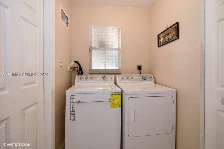19409 NW 24th Place, Pembroke Pines, FL 33029 Laundry area featuring dual panel doors and a central window with horizontal blinds
