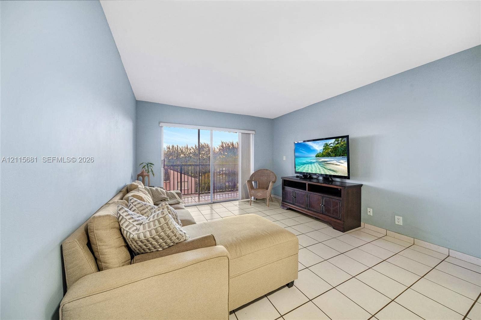 Living area featuring tile flooring and sliding glass doors with access to an exterior balcony