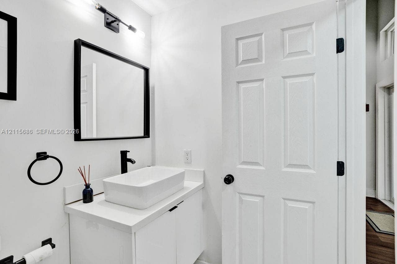 8946 SW 150th Ct Circle E, Miami, Miami, FL 33196 White vanity with a rectangular vessel sink, matte black faucet, framed mirror, and coordinating matte black hardware