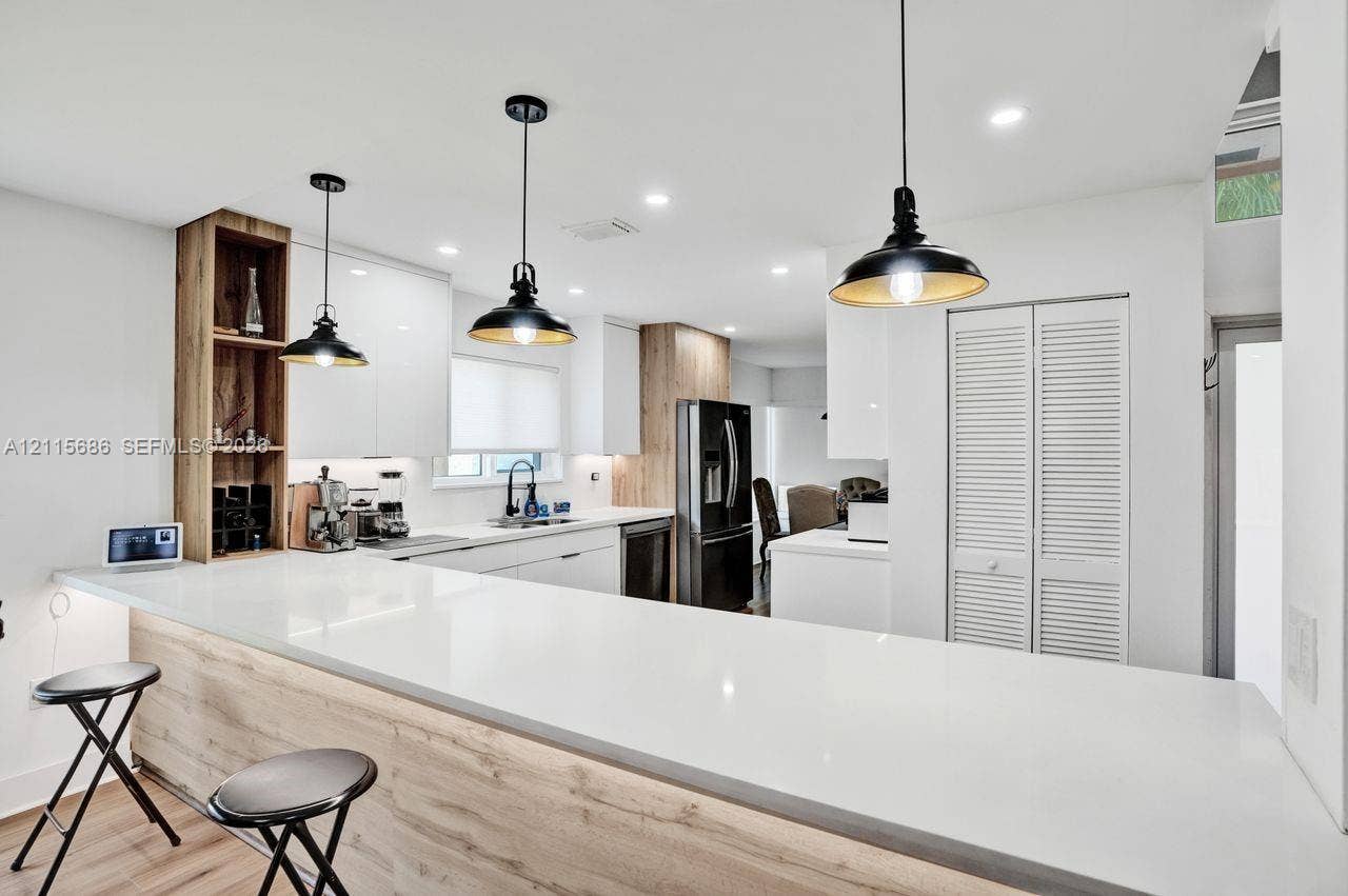 8946 SW 150th Ct Circle E, Miami, Miami, FL 33196 Kitchen featuring white slab-front cabinetry, wood-finish accents, quartz countertops, industrial-style pendant lighting, and recessed ceiling illumination