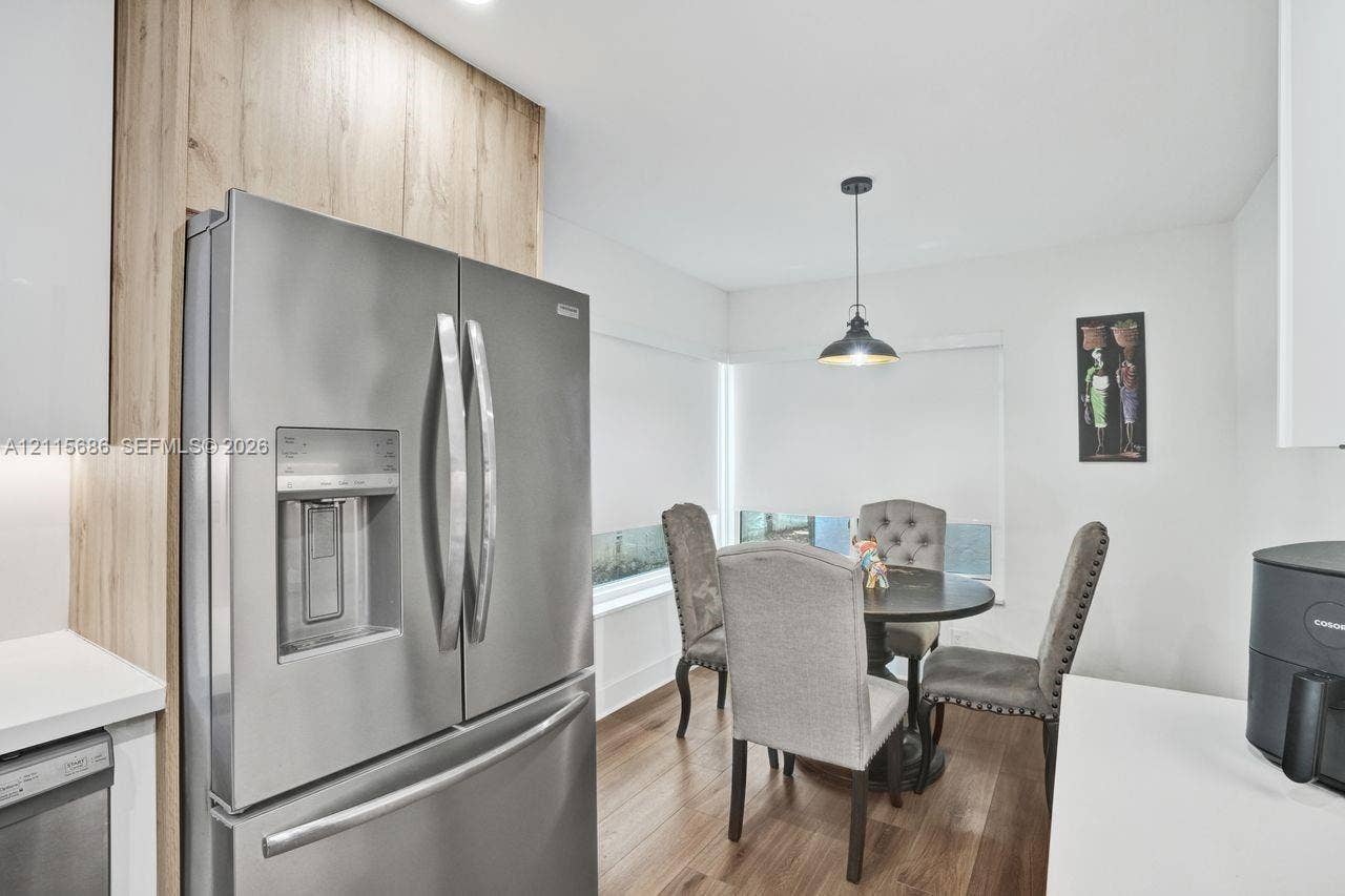 8946 SW 150th Ct Circle E, Miami, Miami, FL 33196 Stainless steel French-door refrigerator, wood-finish cabinetry panels, wood-finish flooring, and industrial-style pendant lighting