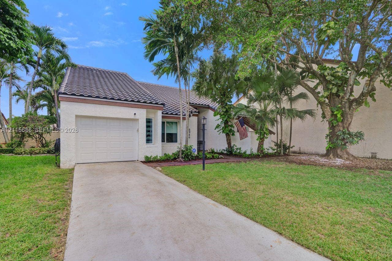 8946 SW 150th Ct Circle E, Miami, Miami, FL 33196 Stucco exterior with a tiled roof, single-car garage, concrete driveway, and mature landscaping