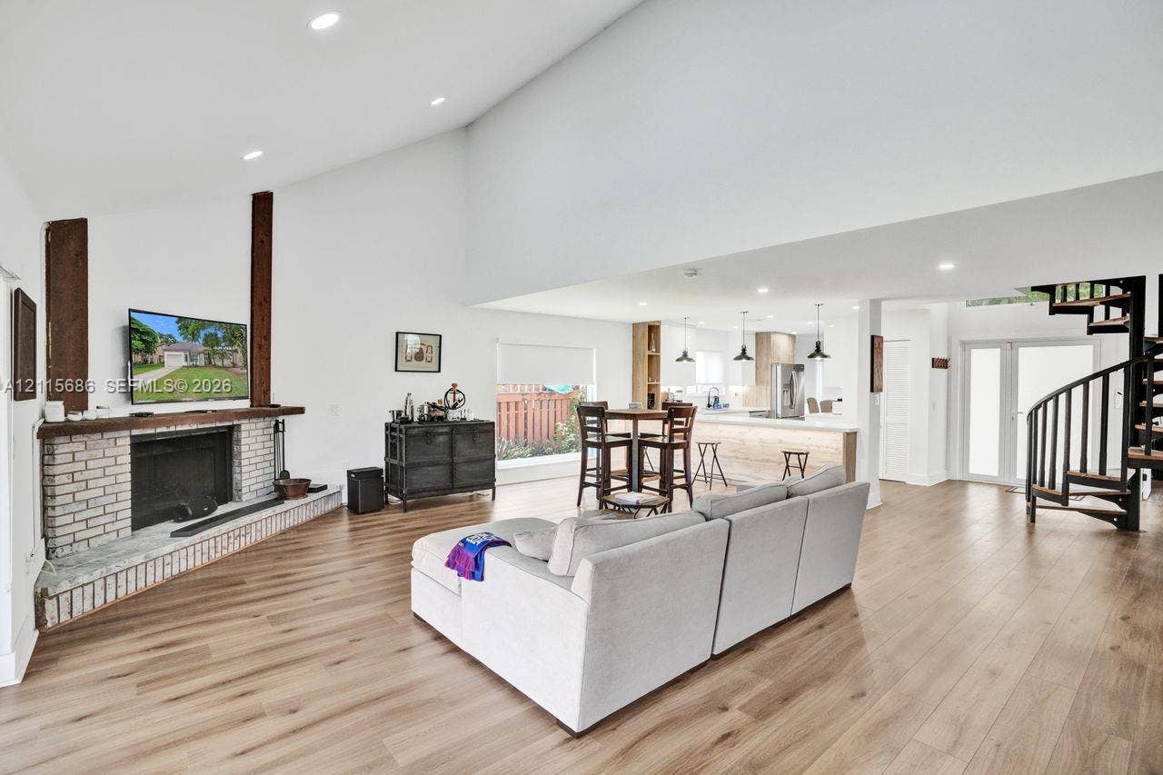8946 SW 150th Ct Circle E, Miami, Miami, FL 33196 Vaulted ceilings with wood-finish flooring, brick-faced fireplace with prominent wood support beams, spiral staircase, and recessed lighting