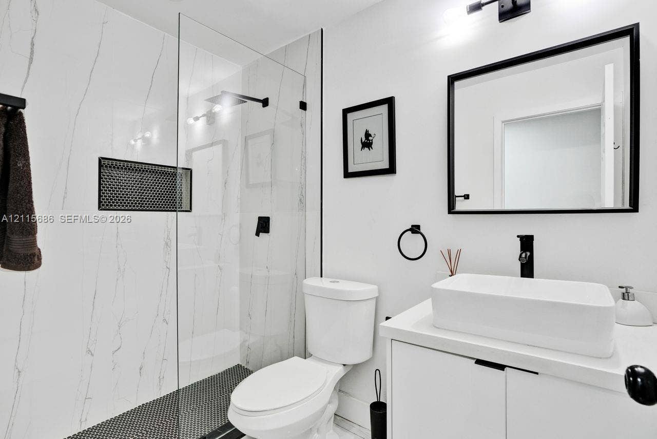 8946 SW 150th Ct Circle E, Miami, Miami, FL 33196 Bathroom featuring a walk-in shower with a frameless glass enclosure, a built-in recessed niche, a modern vanity with a rectangular vessel sink, and matte black fixtures