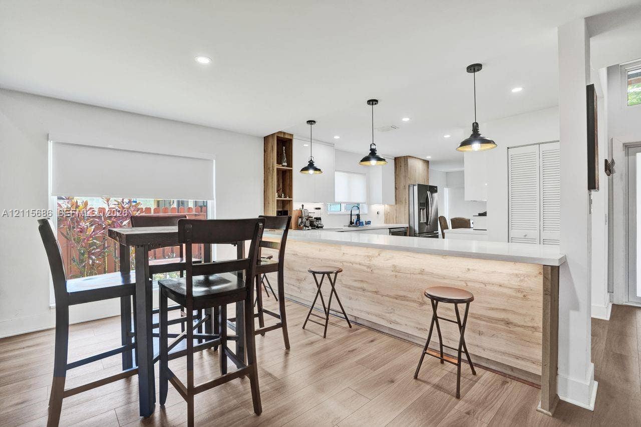 8946 SW 150th Ct Circle E, Miami, Miami, FL 33196 Kitchen featuring a wood-finish island with integrated lighting, wood-finish flooring, recessed ceiling lighting, three pendant lights, and white cabinetry