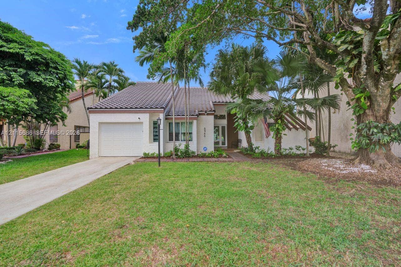 8946 SW 150th Ct Circle E, Miami, Miami, FL 33196 Single-story exterior featuring a tile roof, stucco siding, an attached garage, and mature landscaping