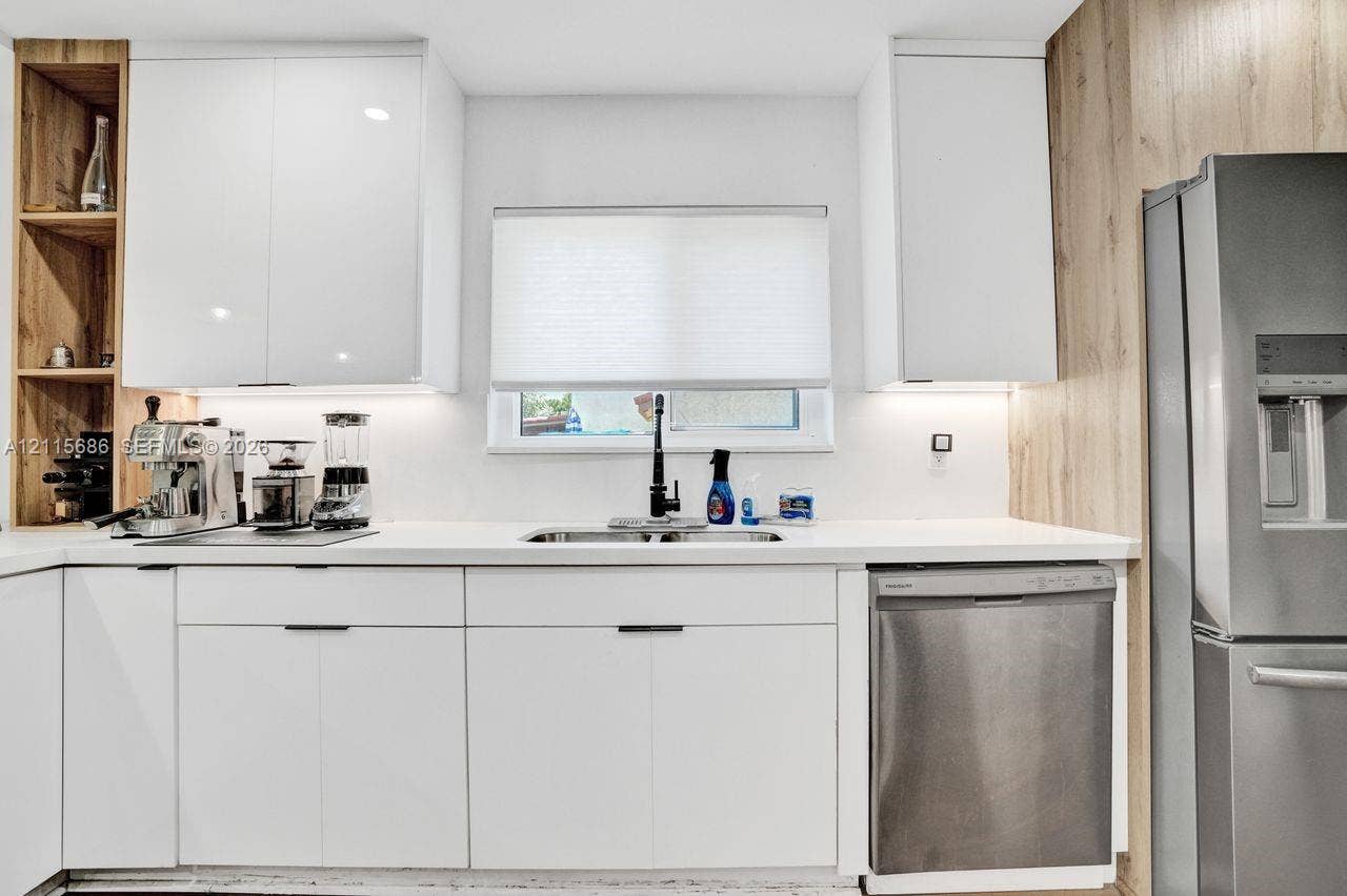 8946 SW 150th Ct Circle E, Miami, Miami, FL 33196 Kitchen featuring white cabinetry, wood-finish shelving, stainless steel appliances, solid surface countertops, and an undermount sink with a high-arch faucet