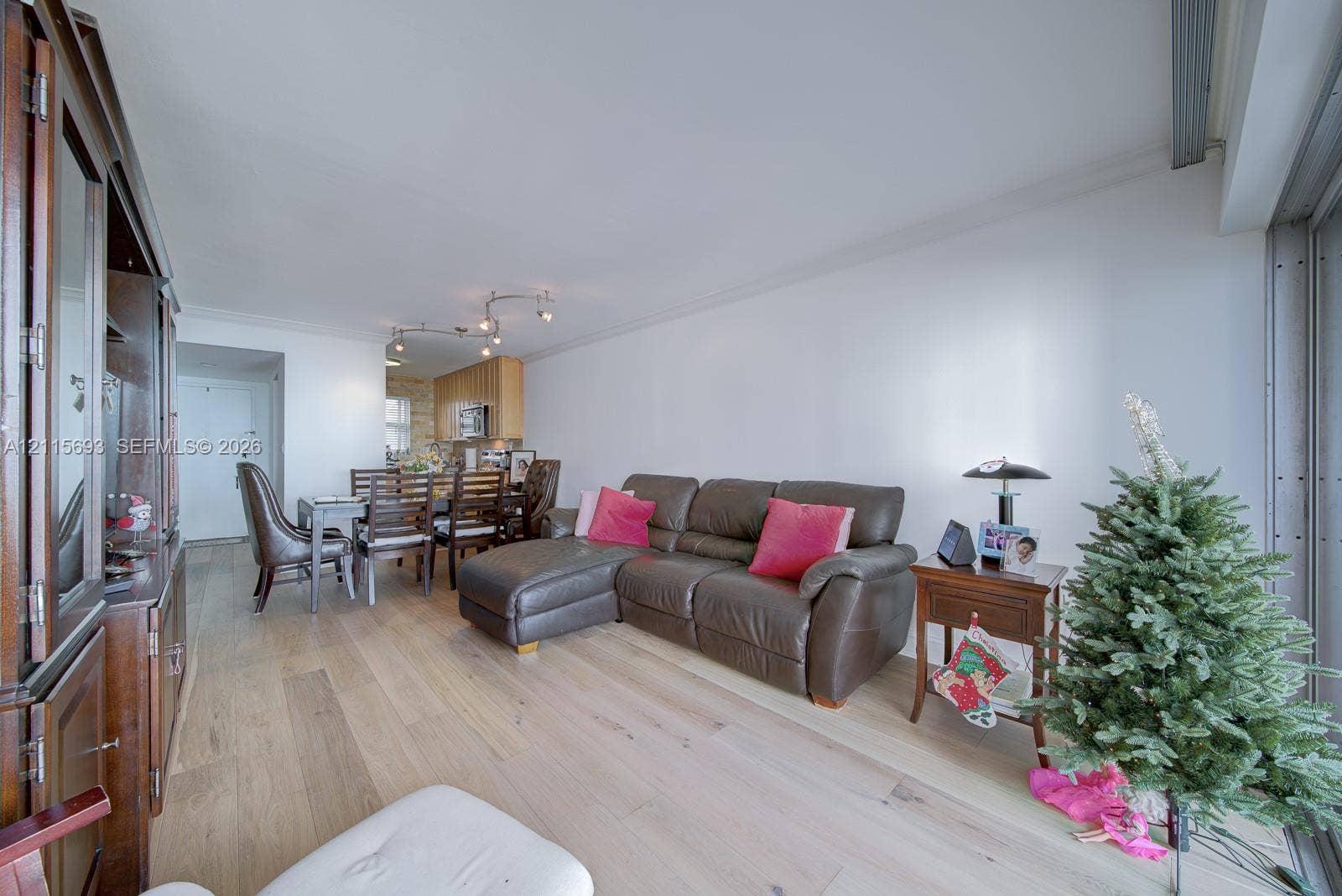 Light wood-finish flooring, recessed track lighting, and built-in wood cabinetry