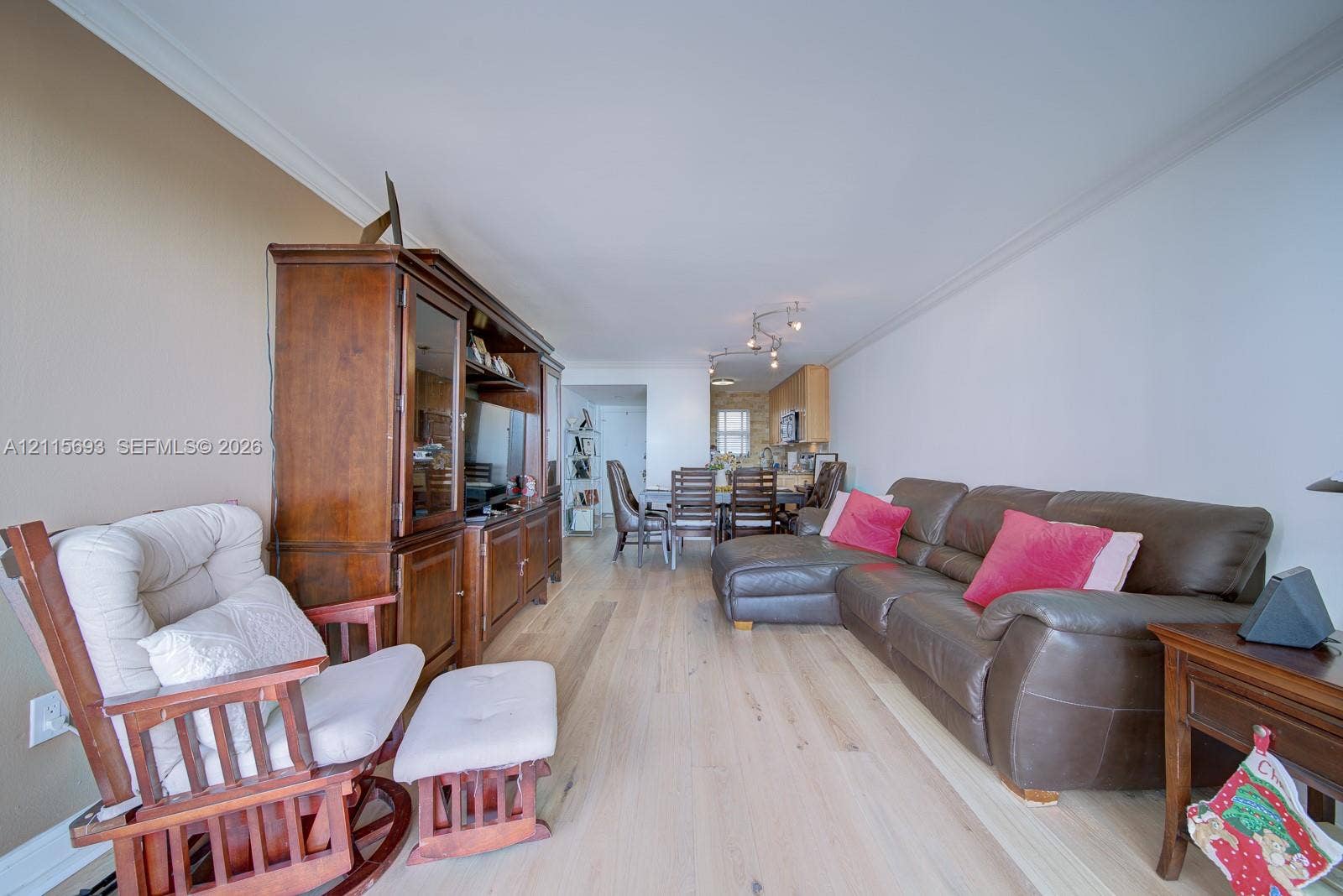 Living area featuring light-toned wood-finish flooring, neutral wall paint, and multi-light track ceiling fixtures