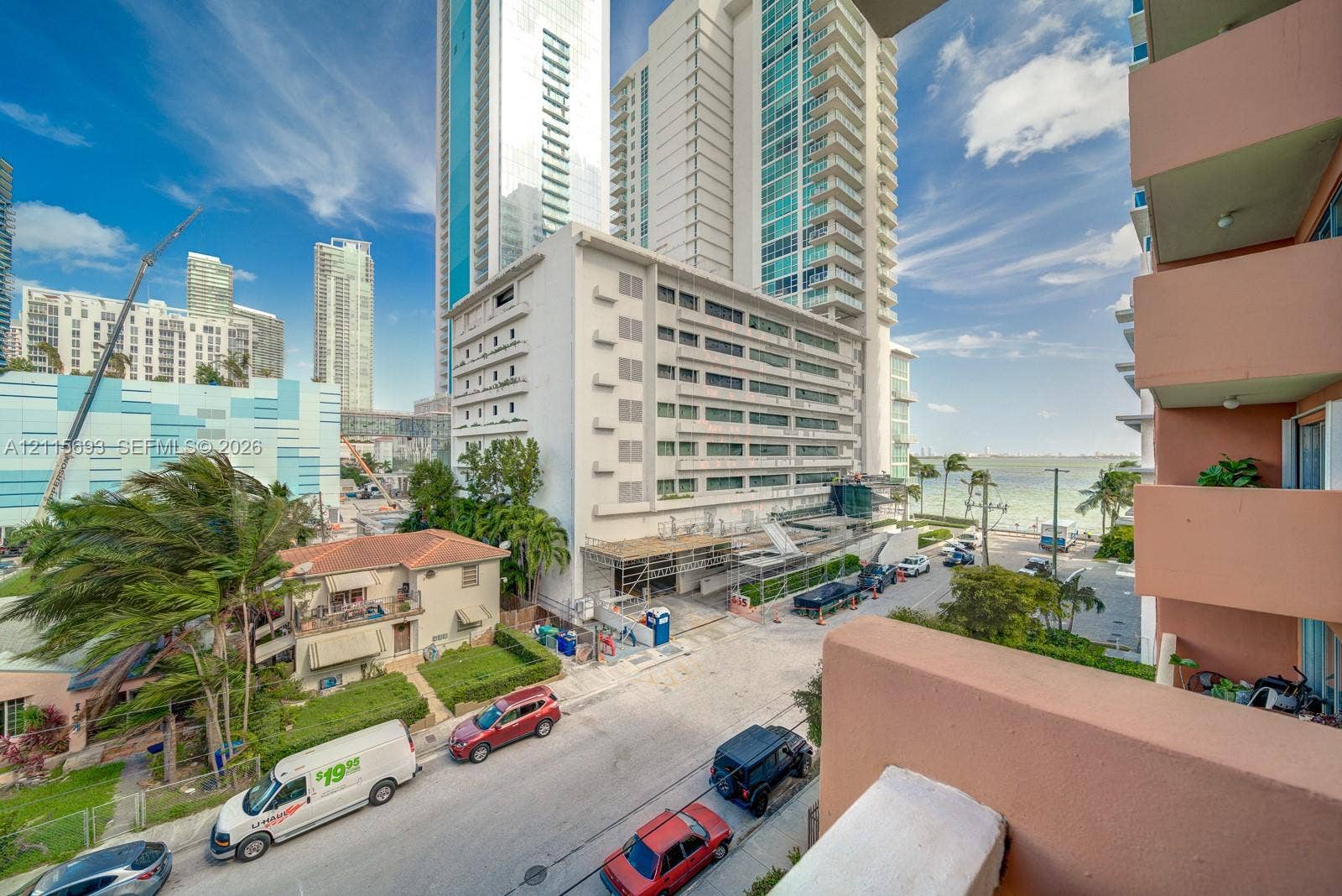 High-rise urban building featuring multiple stacked concrete balconies and proximity to the coastal shoreline