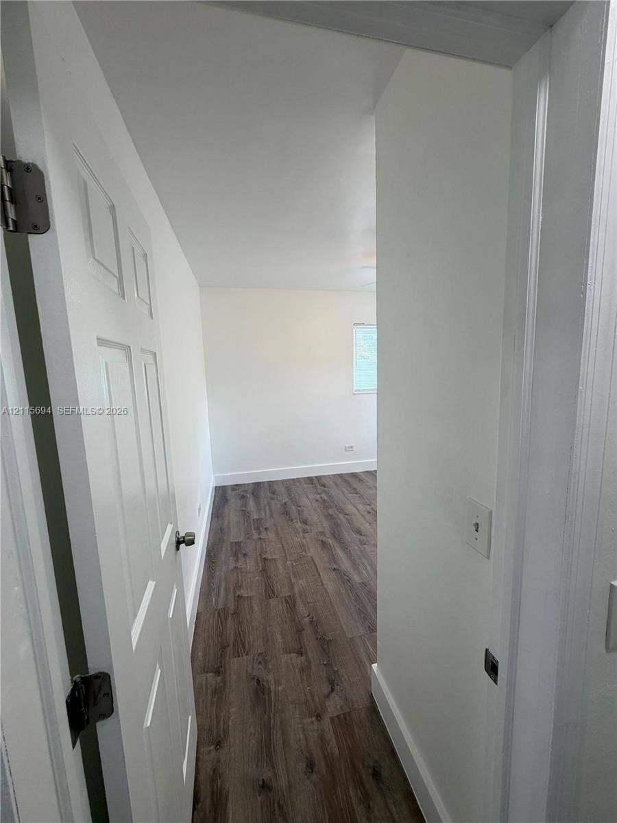 619 SW 7th Avenue, #7, Miami, Miami, FL 33130 Interior space featuring wood-finish flooring, a multi-panel door, and a recessed window
