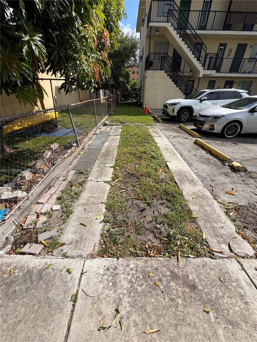 619 SW 7th Avenue, #7, Miami, Miami, FL 33130 Asphalt parking area featuring concrete tire strips and metal chain-link perimeter fencing