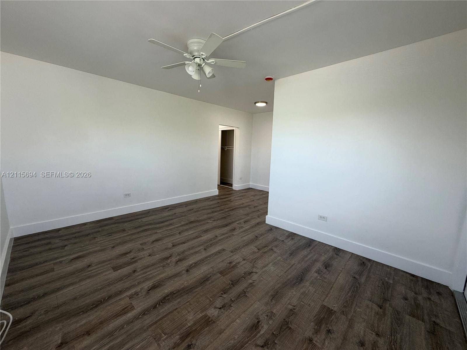 619 SW 7th Avenue, #7, Miami, Miami, FL 33130 Room featuring wood-finish flooring, white walls, and a ceiling fan with integrated lighting