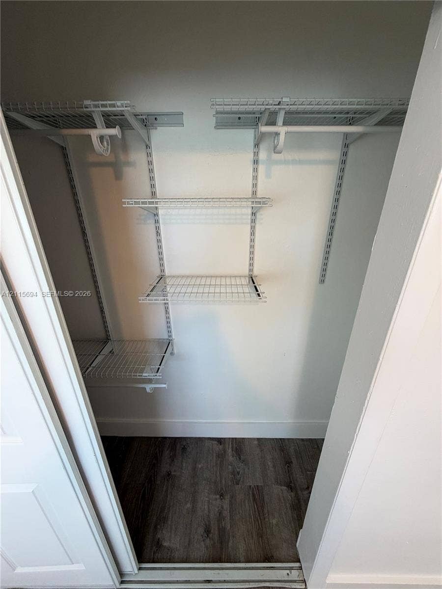 619 SW 7th Avenue, #7, Miami, Miami, FL 33130 Storage closet featuring white wire shelving, dual hanging rods, and wood-finish flooring