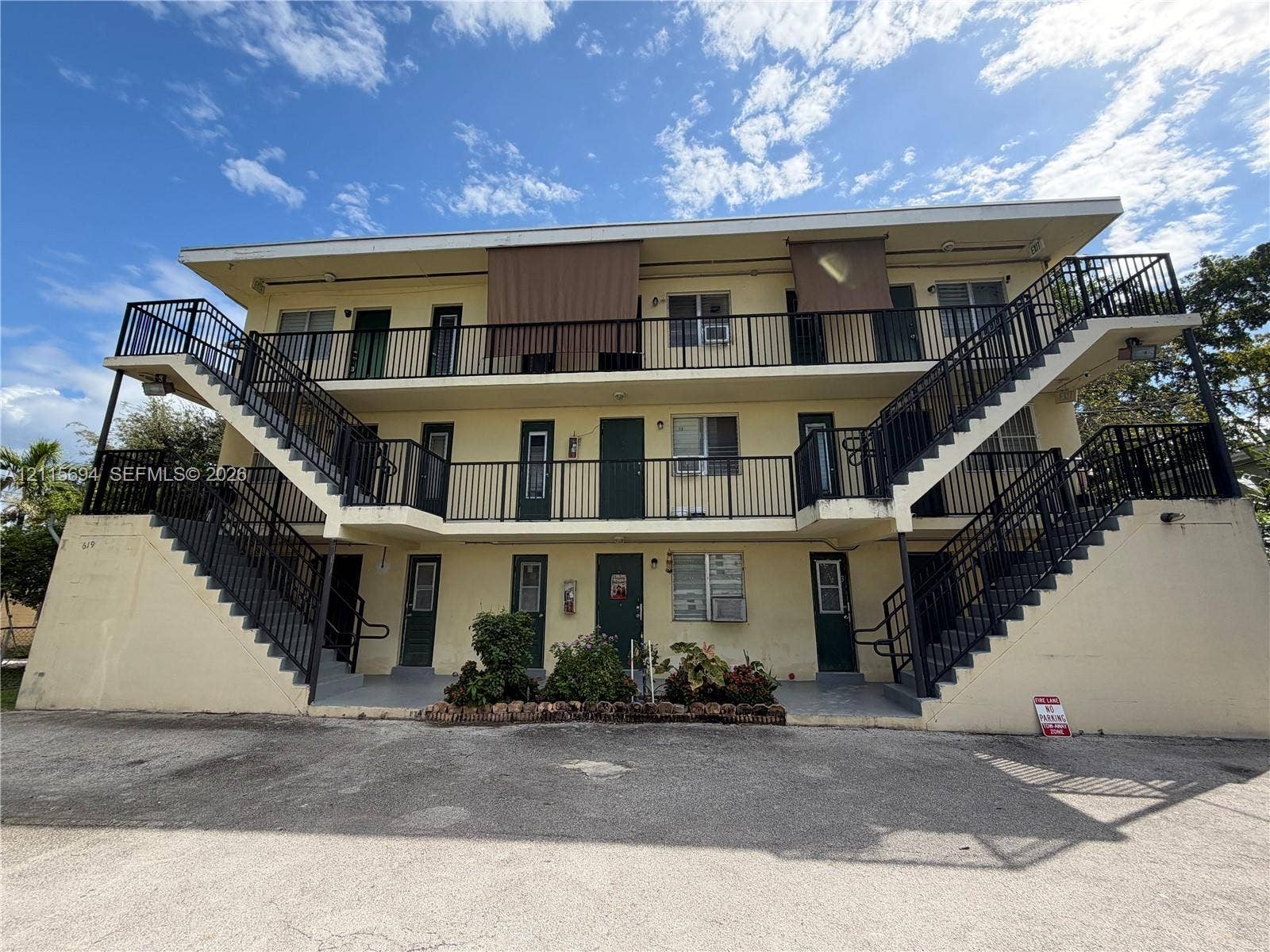 619 SW 7th Avenue, #7, Miami, Miami, FL 33130 Three-story multi-unit exterior featuring concrete construction, dual symmetrical staircases, metal railings, and exterior walkways