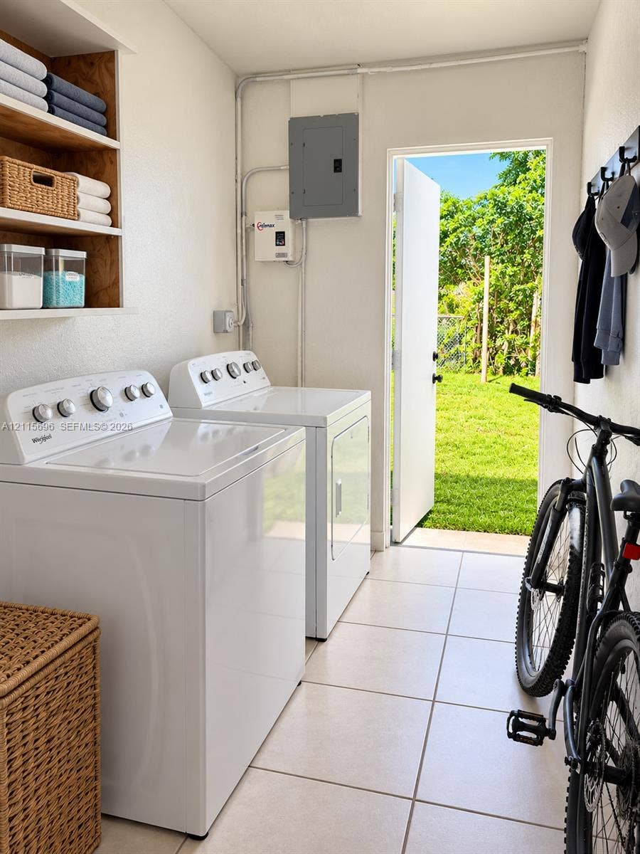 1101 NW 55th Avenue, #B, Lauderhill, Lauderhill, FL 33313 Laundry area featuring built-in wooden shelving, ceramic tile flooring, and direct exterior access to a grass lawn