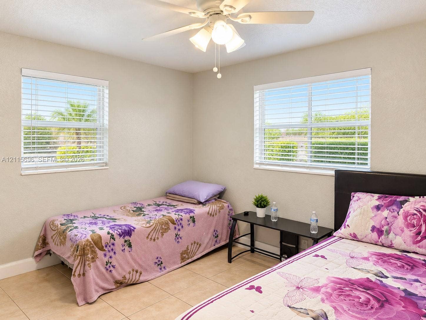 1101 NW 55th Avenue, #B, Lauderhill, Lauderhill, FL 33313 Neutral wall palette featuring dual windows with horizontal blinds, neutral tile flooring, and a ceiling-mounted light fixture with fan