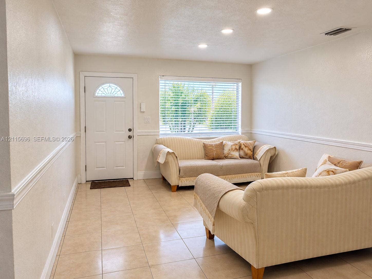 1101 NW 55th Avenue, #B, Lauderhill, Lauderhill, FL 33313 Neutral tile flooring, recessed lighting, white chair rail molding, and a front entry door featuring a decorative glass transom window