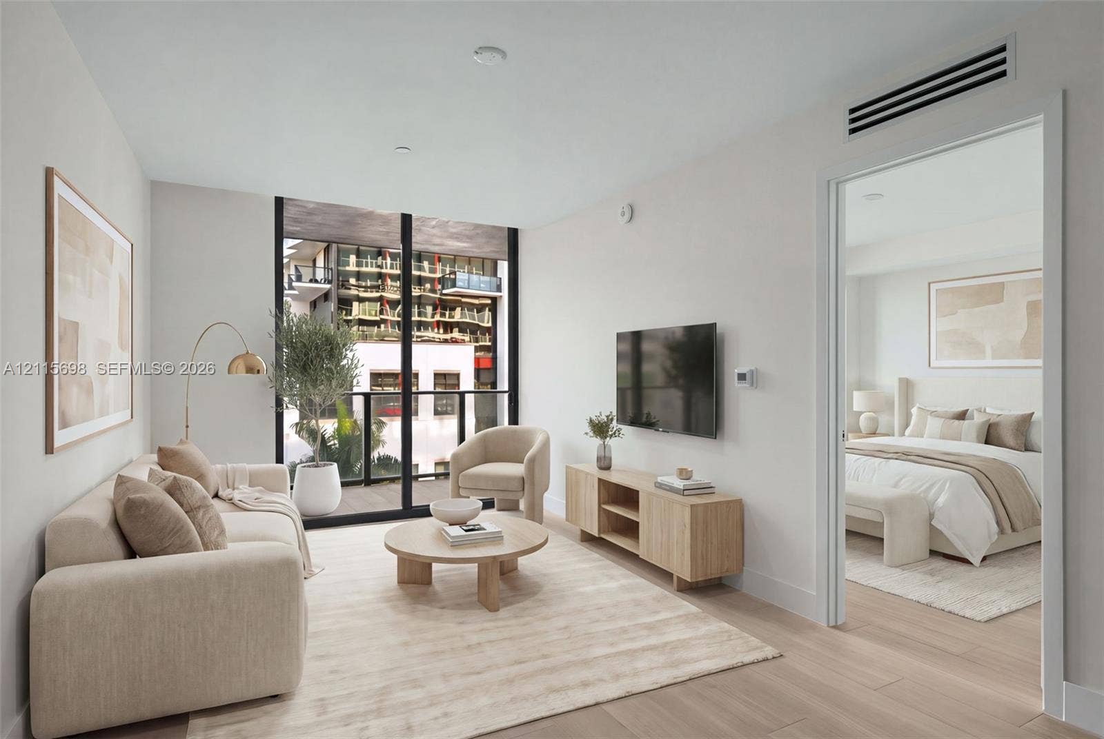 Floor-to-ceiling windows, wood-finish flooring, and a private balcony