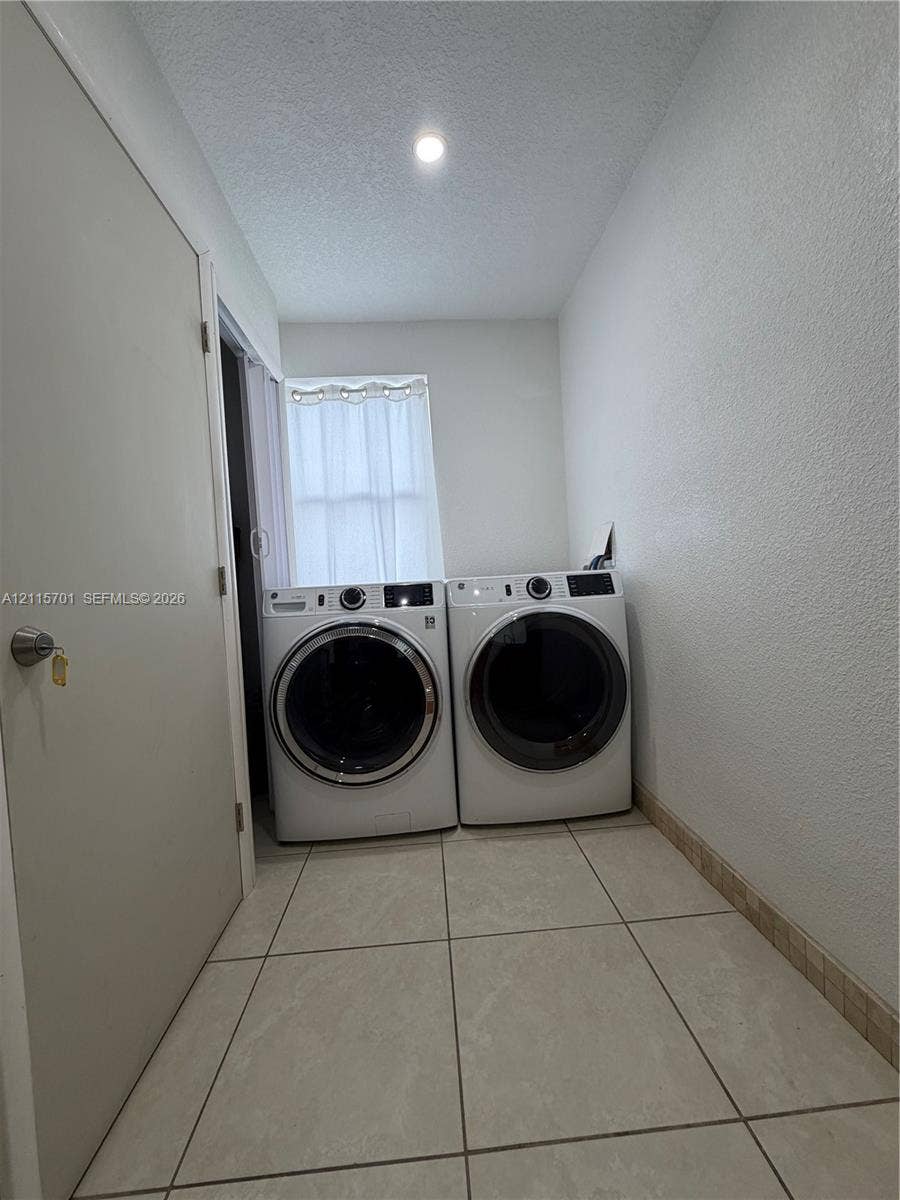 8641 NW 25th Court, #864, Sunrise, Sunrise, FL 33322 Utility area featuring large-format ceramic tile flooring, neutral wall finishes, and recessed ceiling lighting