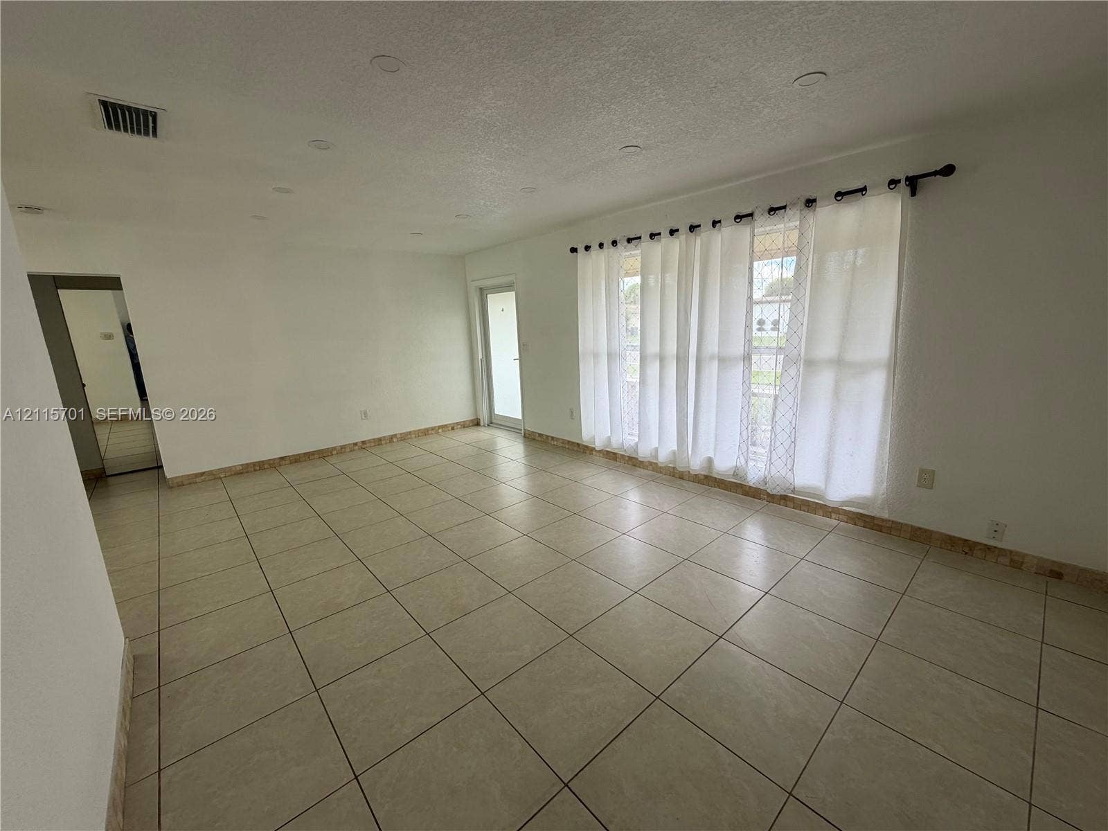 8641 NW 25th Court, #864, Sunrise, Sunrise, FL 33322 Interior room featuring large-format ceramic tile flooring, recessed lighting, and a glass-paneled exterior door