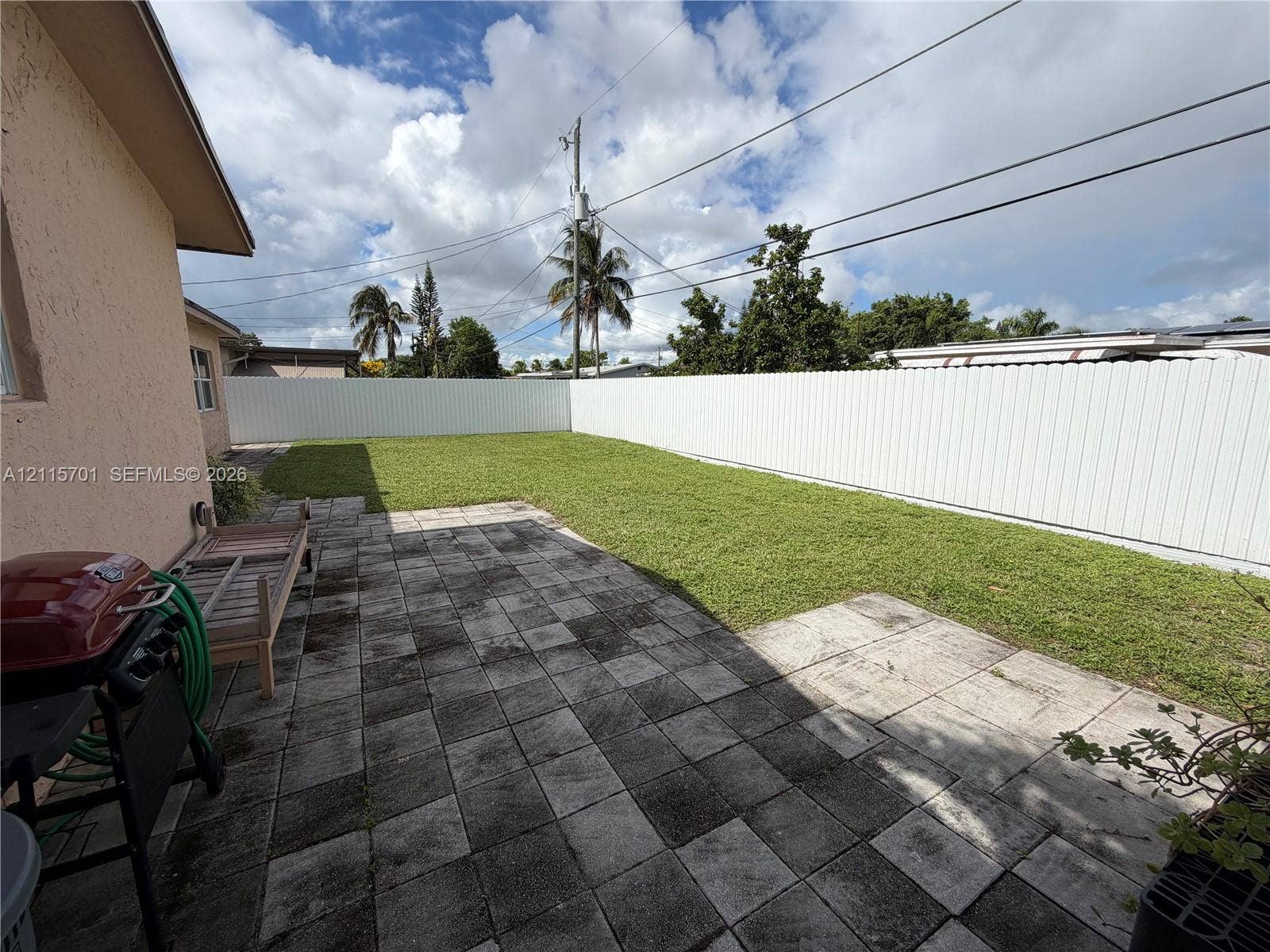 8641 NW 25th Court, #864, Sunrise, Sunrise, FL 33322 Backyard featuring a paved stone patio, a level lawn, and a white vinyl privacy fence