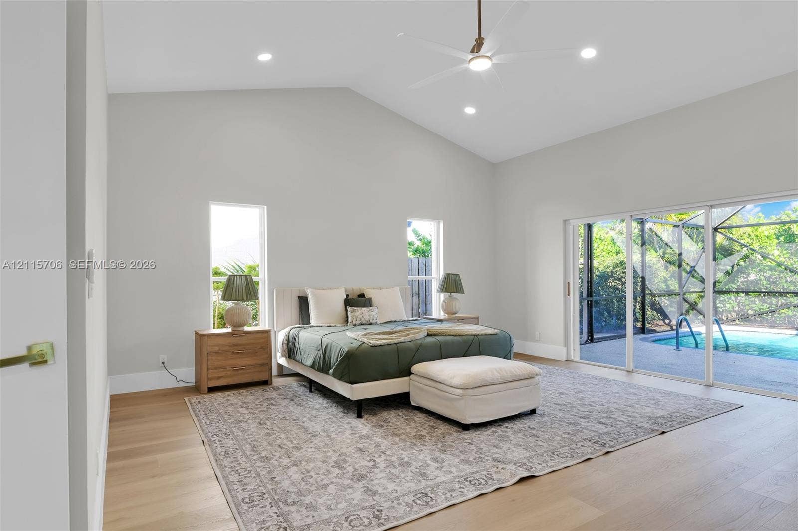5184 Deerhurst Crescent Circle, Boca Raton, FL 33486 Vaulted ceiling featuring recessed lighting and a central ceiling fan, wood-finish flooring, and sliding glass doors with direct access to a screened-in swimming pool