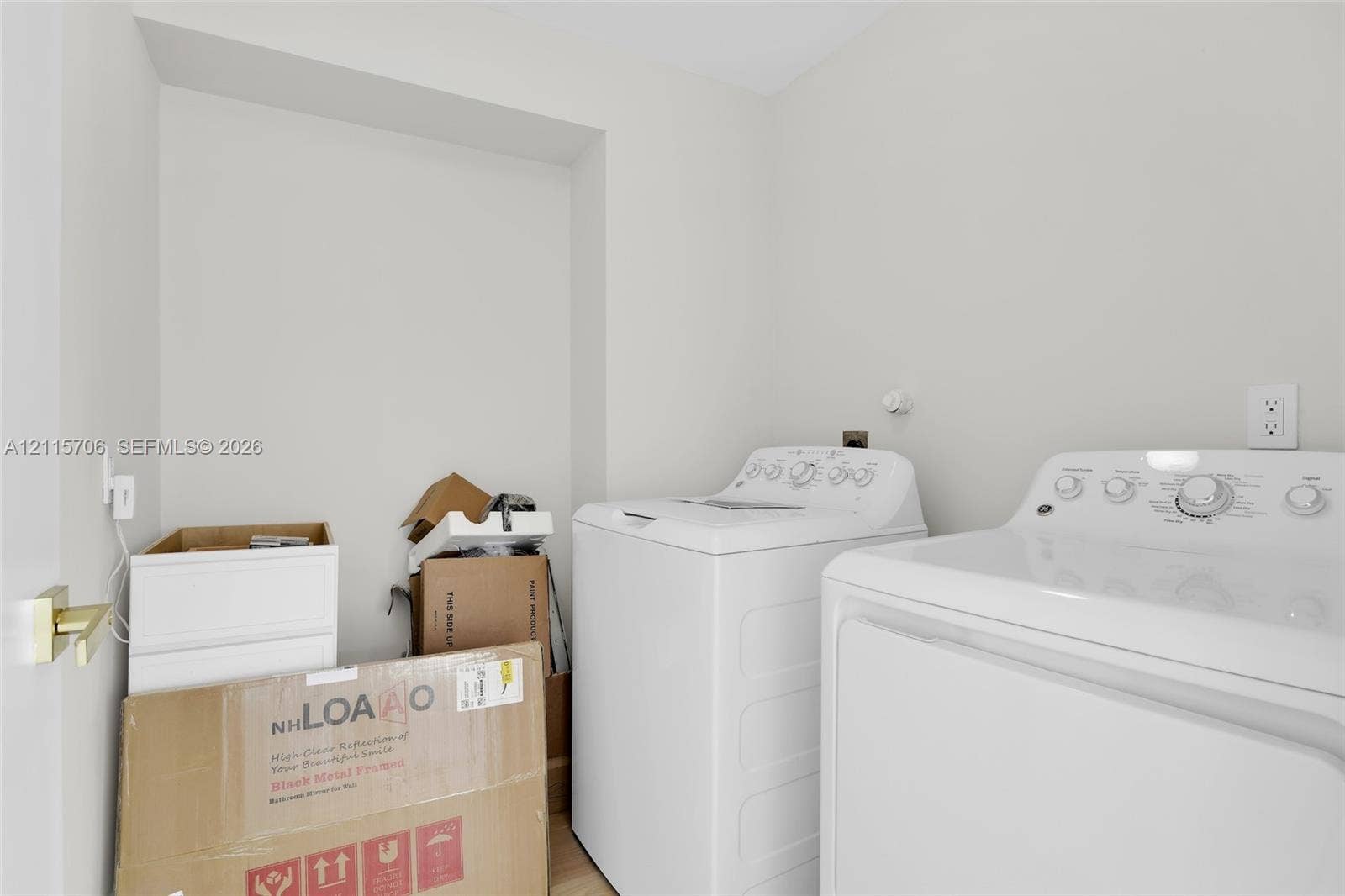 5184 Deerhurst Crescent Circle, Boca Raton, FL 33486 Dedicated laundry area featuring a white top-load washer, white electric dryer, and gold-finish door hardware
